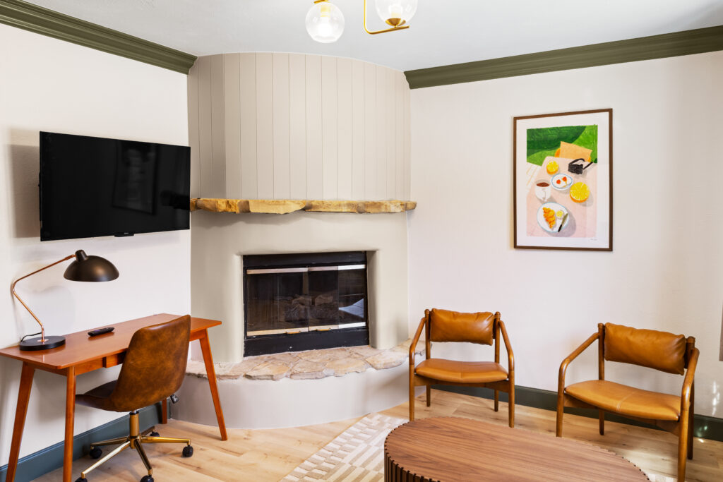 Room with fireplace and seating with art and desk