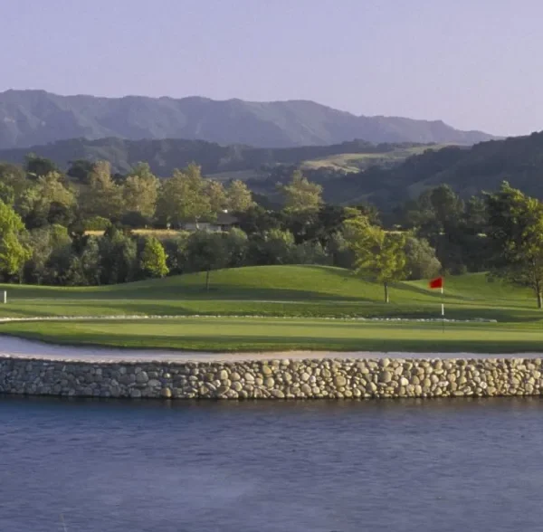 Golf Course hole pin flag on rocky banks canal USA CA